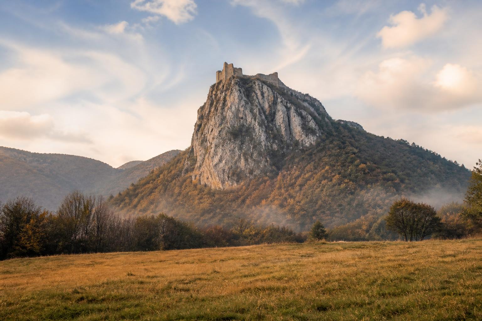 Le pog de Montségur vu depuis le prat dels cremats, le château perché sur son piton rocheux dans la brume légère d'automne