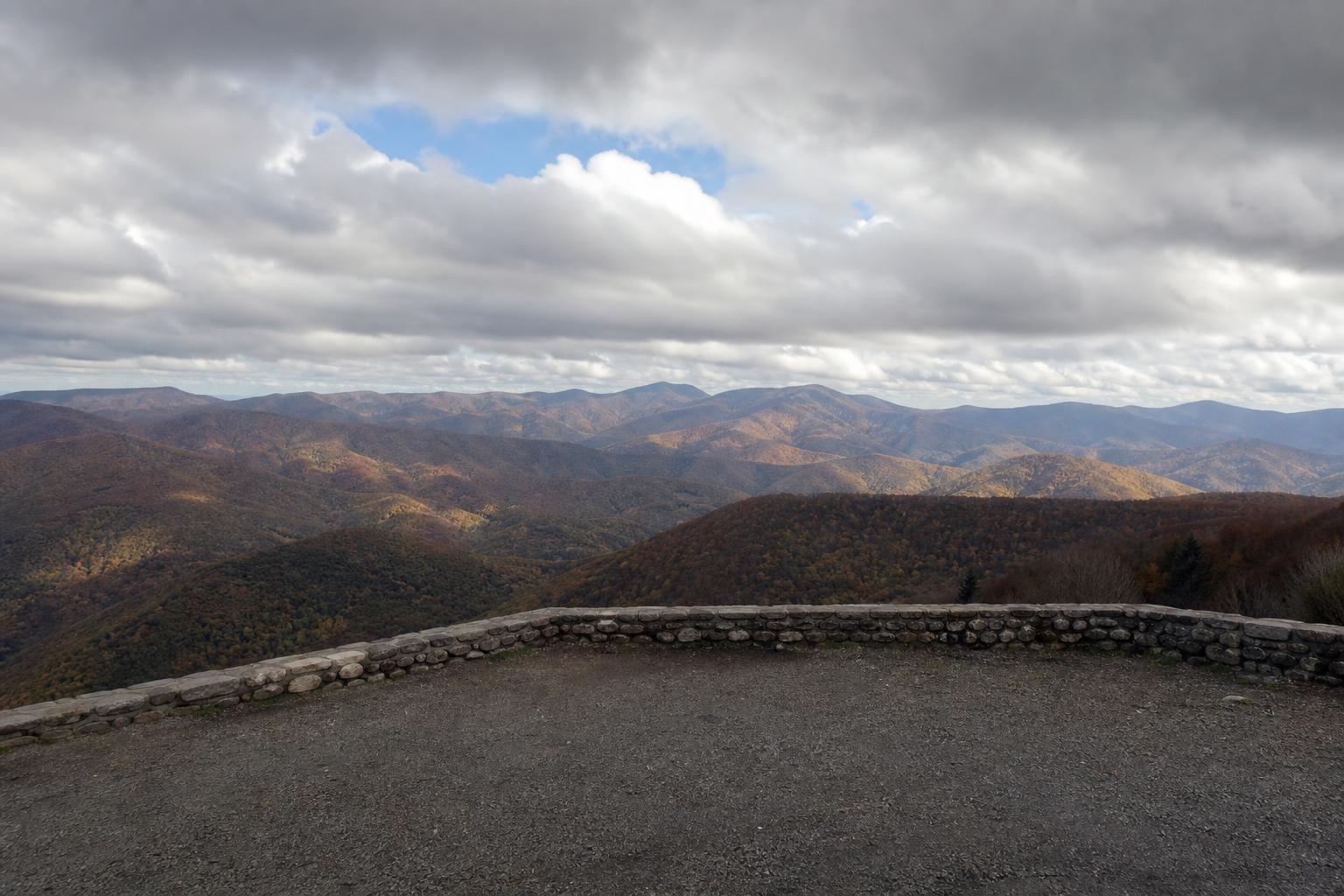 Vue panoramique depuis le col de Bagargiak à 1327 mètres, forêt de hêtres aux couleurs d'automne à perte de vue, parking désert, ciel chargé